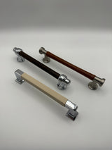 Three leather-wrapped pulls in cream, dark brown and tan leather with chrome and nickel hardware